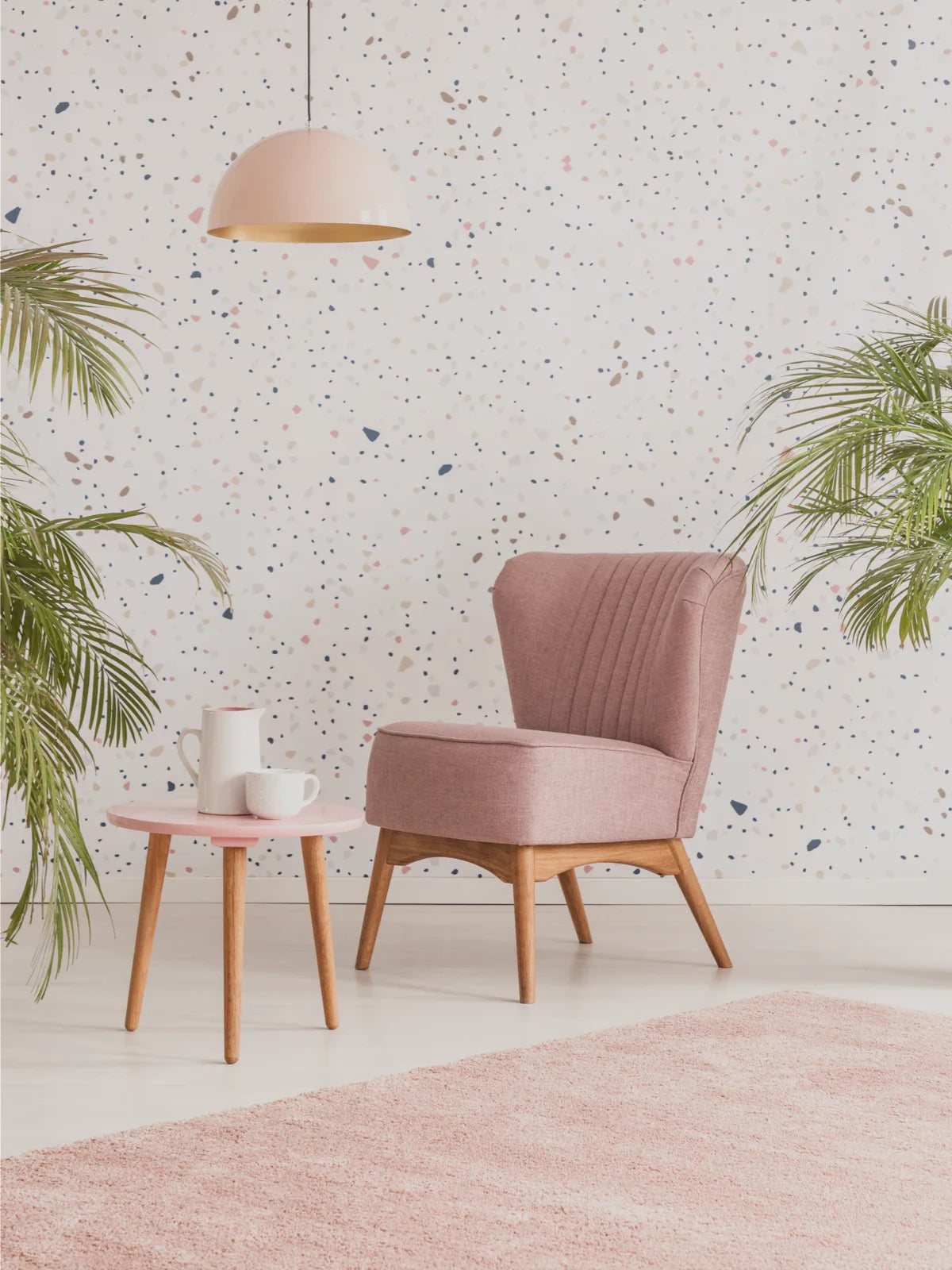A cozy and stylish interior featuring a soft pink rug, a matching pink accent chair, and a wooden side table, creating a warm and inviting atmosphere.