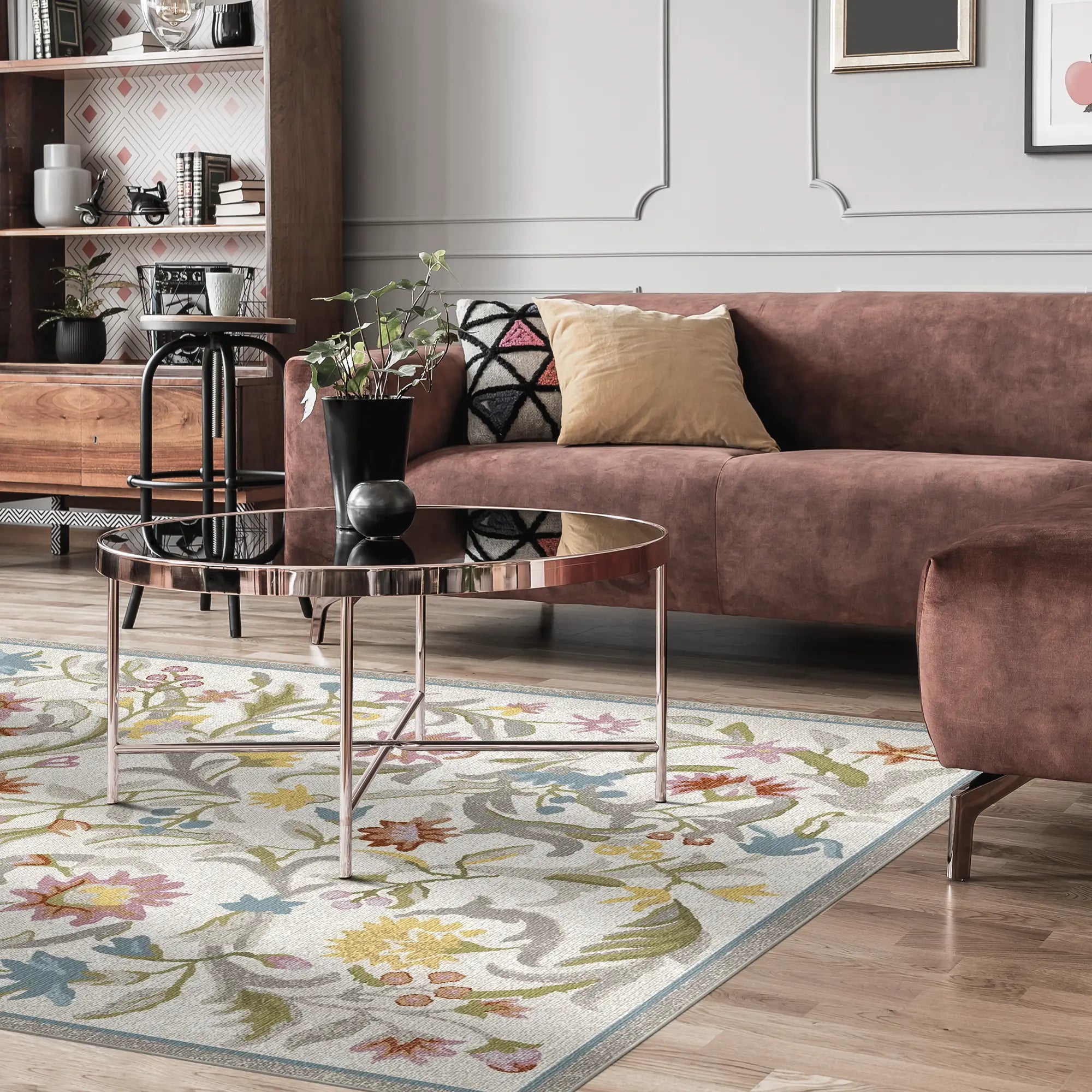 Wohnzimmer mit einem Blumenmuster-Teppich, braunem Sofa und Couchtisch.