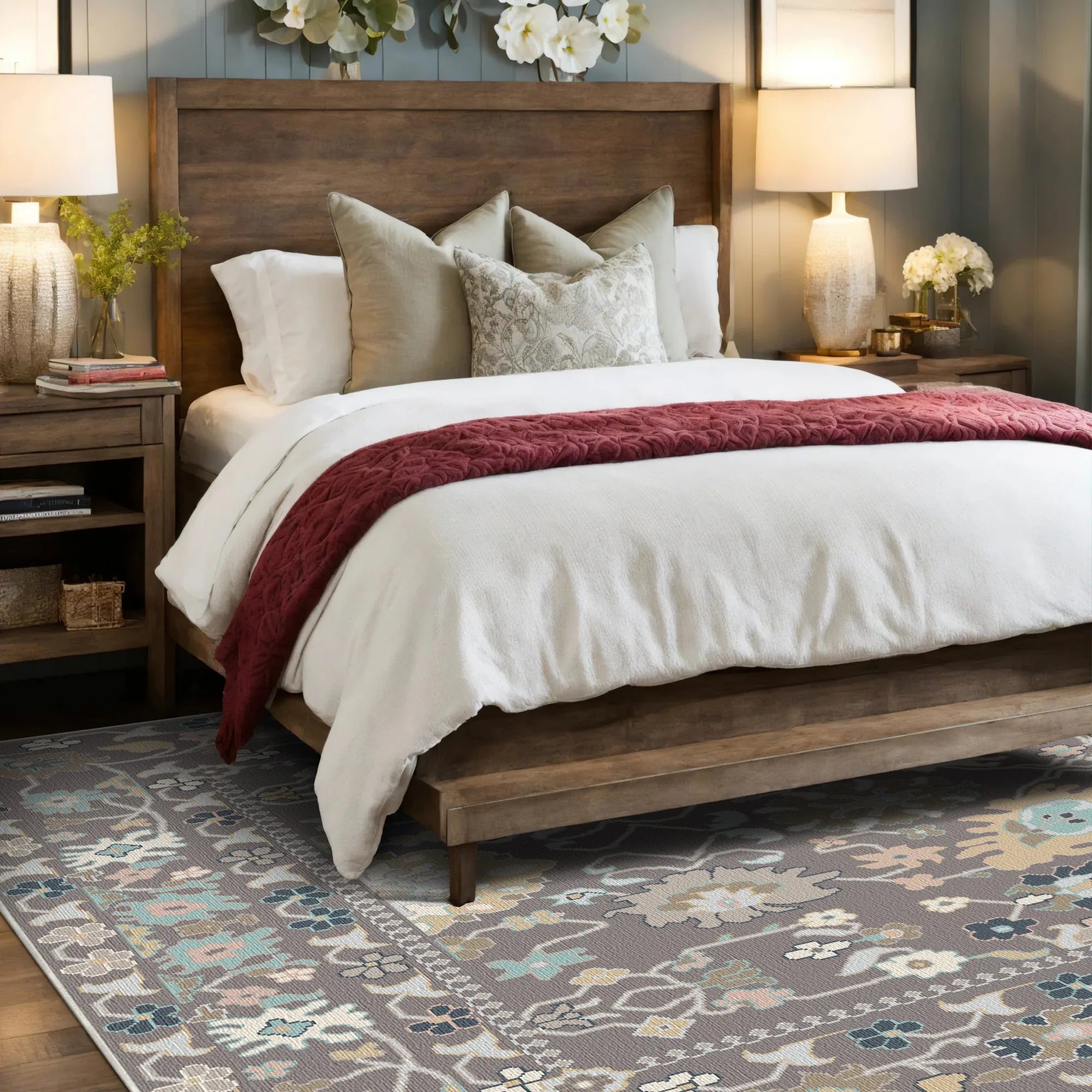 Teppich mit pastellfarbenem Blumenmuster in Blau, Beige und Grau unter einem Holzbettrahmen