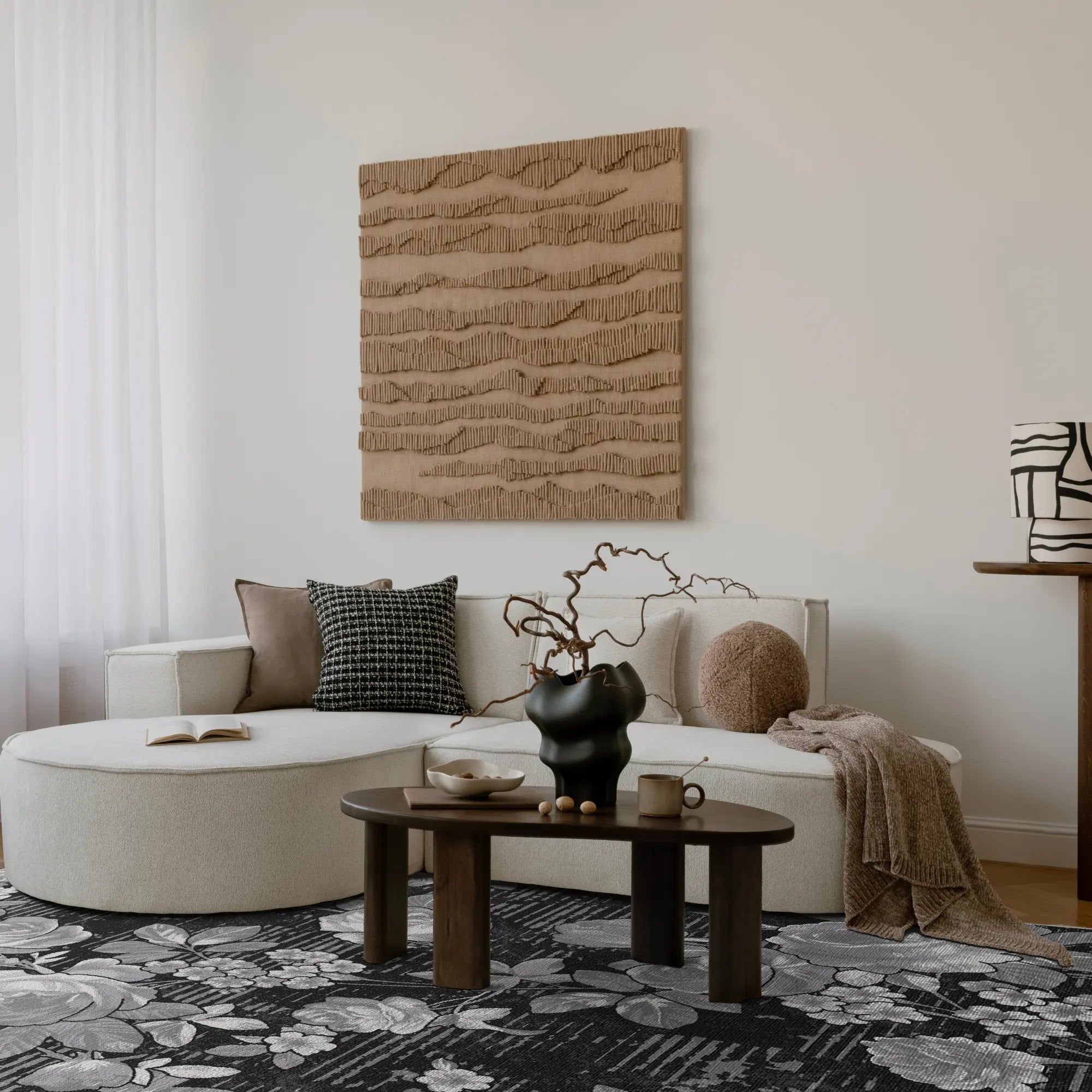 Modernes Wohnzimmer mit einem weißen Ecksofa, einem hölzernen Couchtisch und strukturierter Wandkunst.