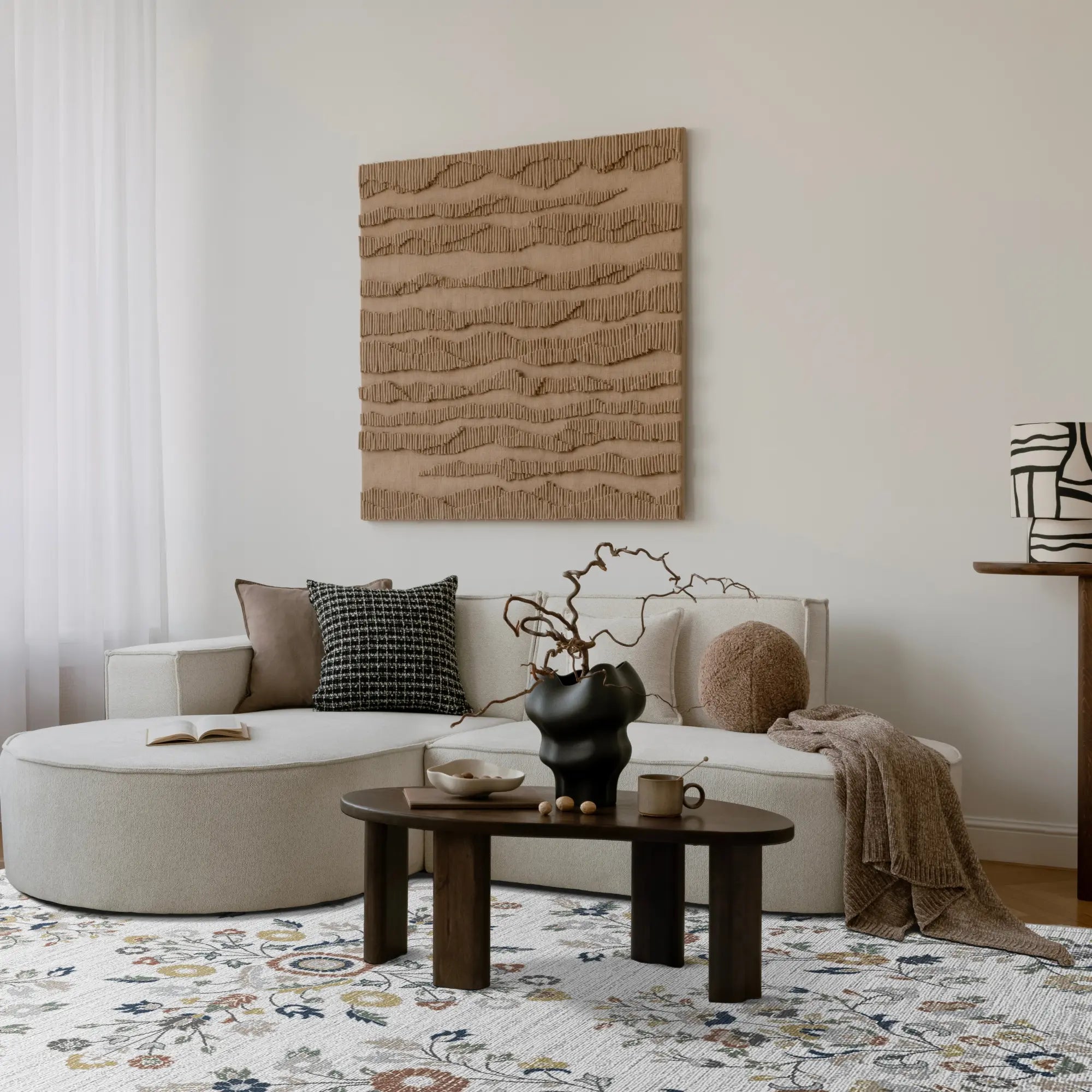 Modernes Wohnzimmer mit einem beigen Ecksofa, einem hölzernen Couchtisch und strukturierter Wandkunst.