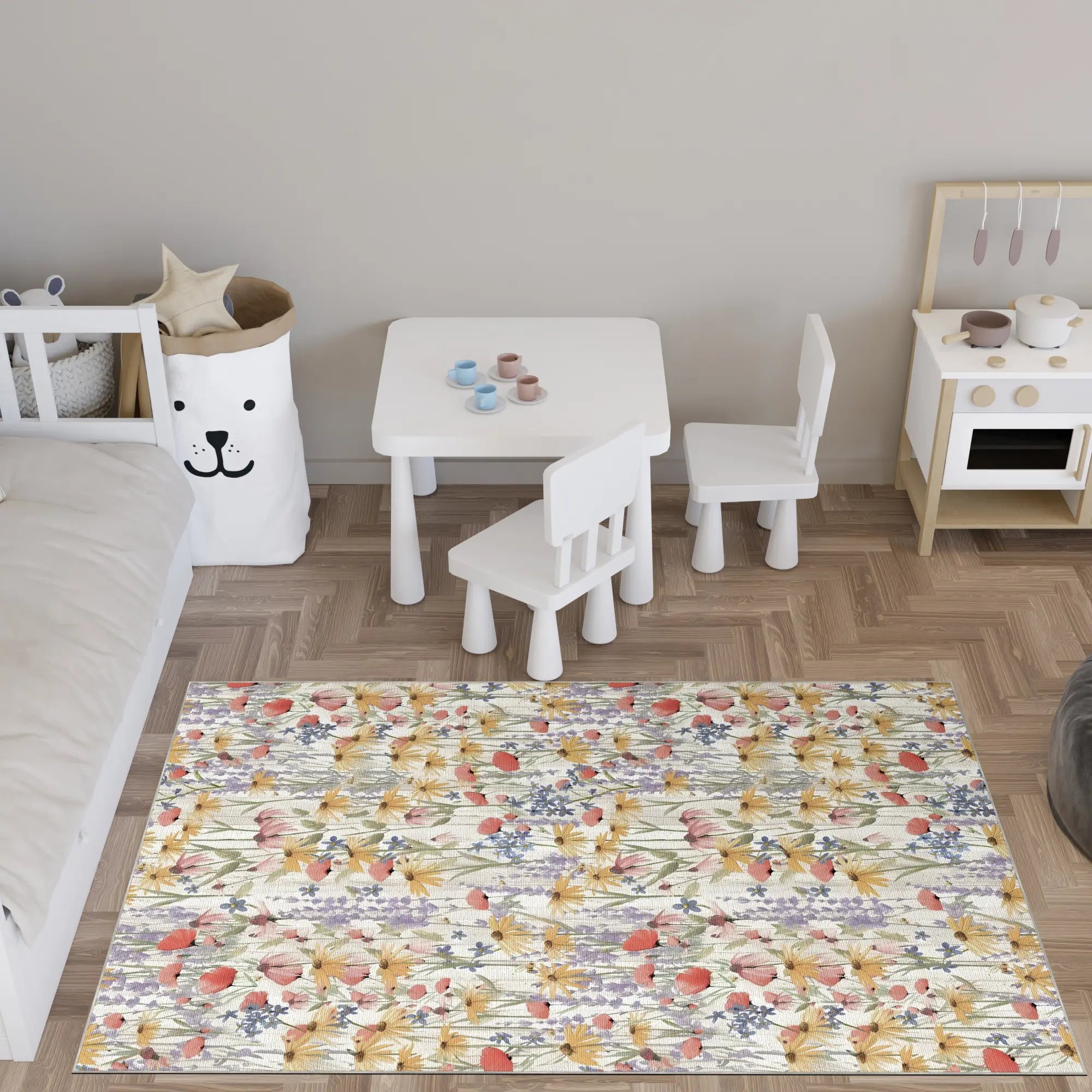 Kinderspielbereich mit einem Teppich im Blumenmuster, Tisch und Stühlen auf einem Holzboden.