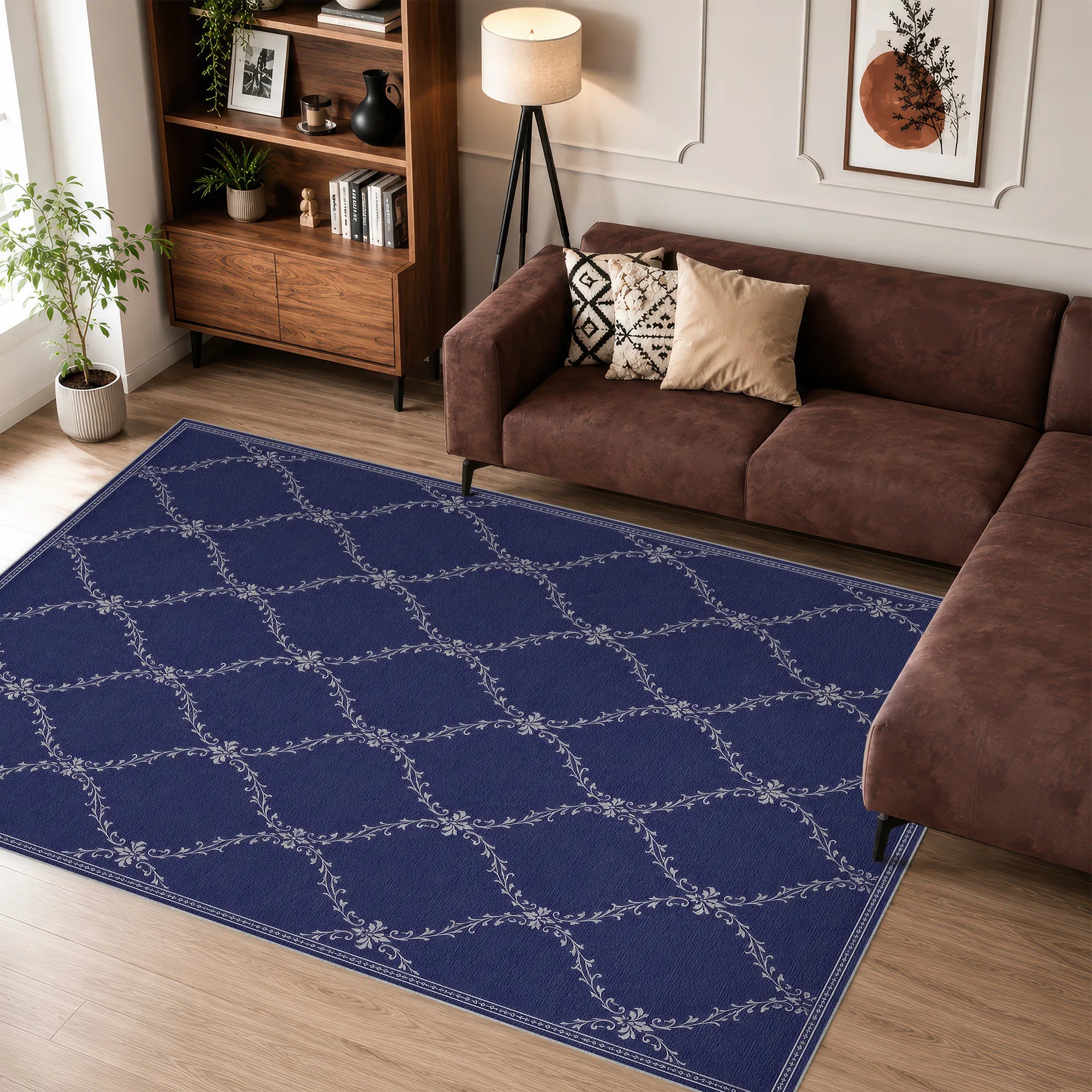 A navy blue lattice area rug with a white trellis pattern is shown in a modern living room setting next to a brown sectional sofa and wooden bookshelf.