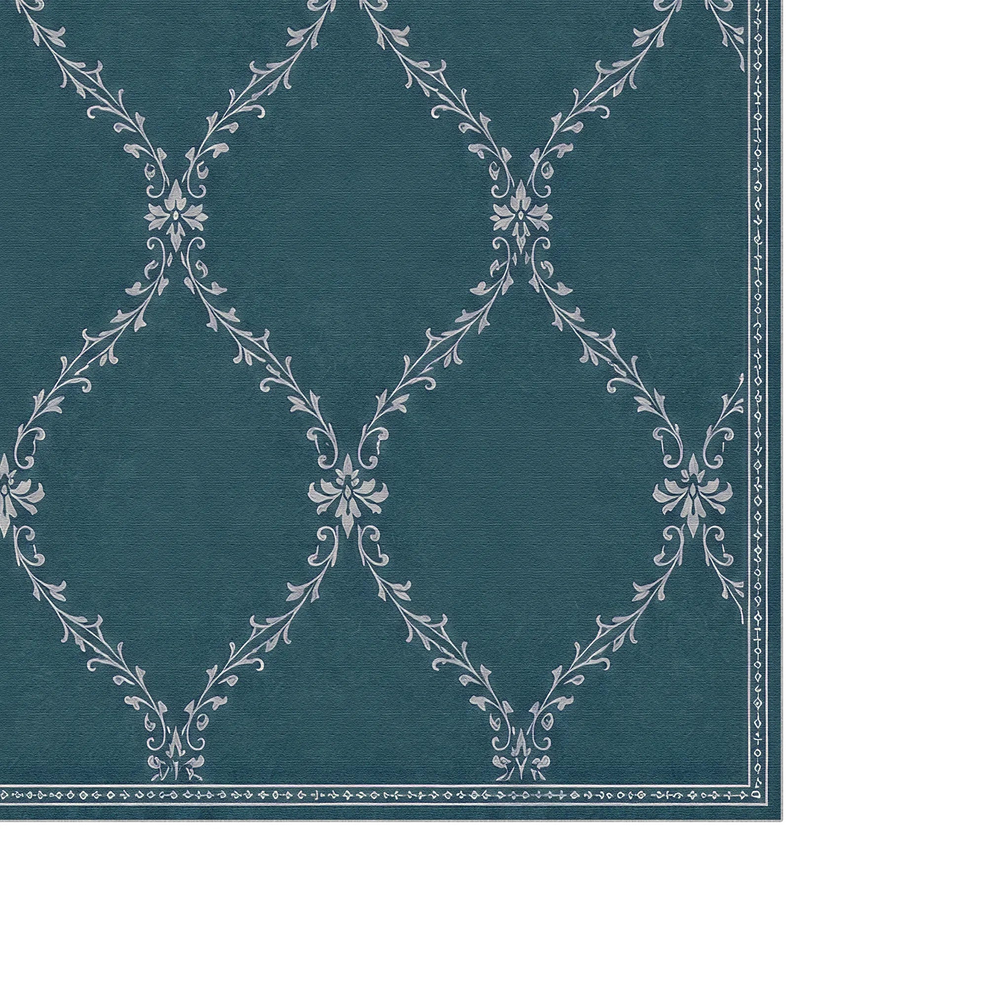 A close-up of a teal blue lattice washable area rug with a white damask-style floral pattern and a decorative border, shown against a white background.