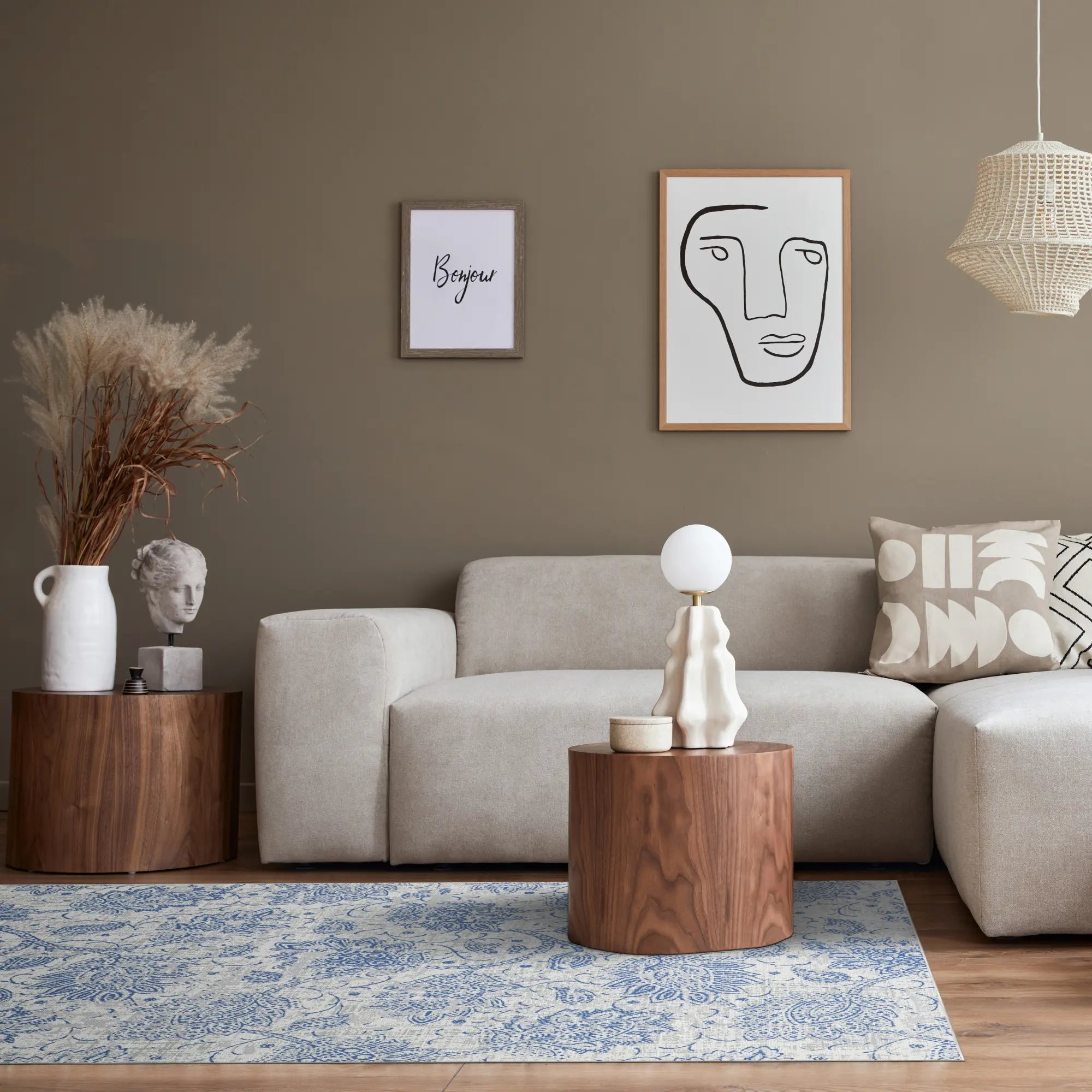 Modernes Wohnzimmer mit blauem Teppich, grauem Sofa, hölzernem Beistelltisch und abstrakter Kunst an der Wand.