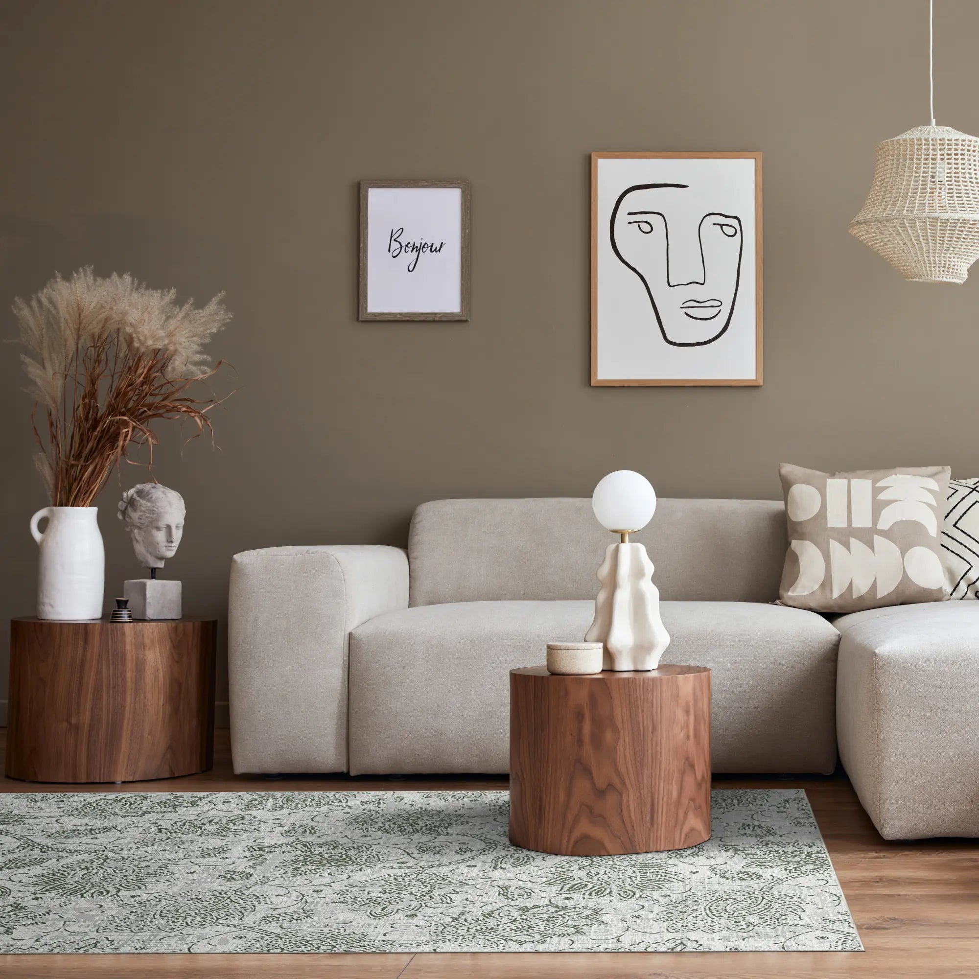 Modernes Wohnzimmer mit einem abstrakten Teppich, beigem Sofa, einem hölzernen Beistelltisch und abstrakter Kunst an der Wand.