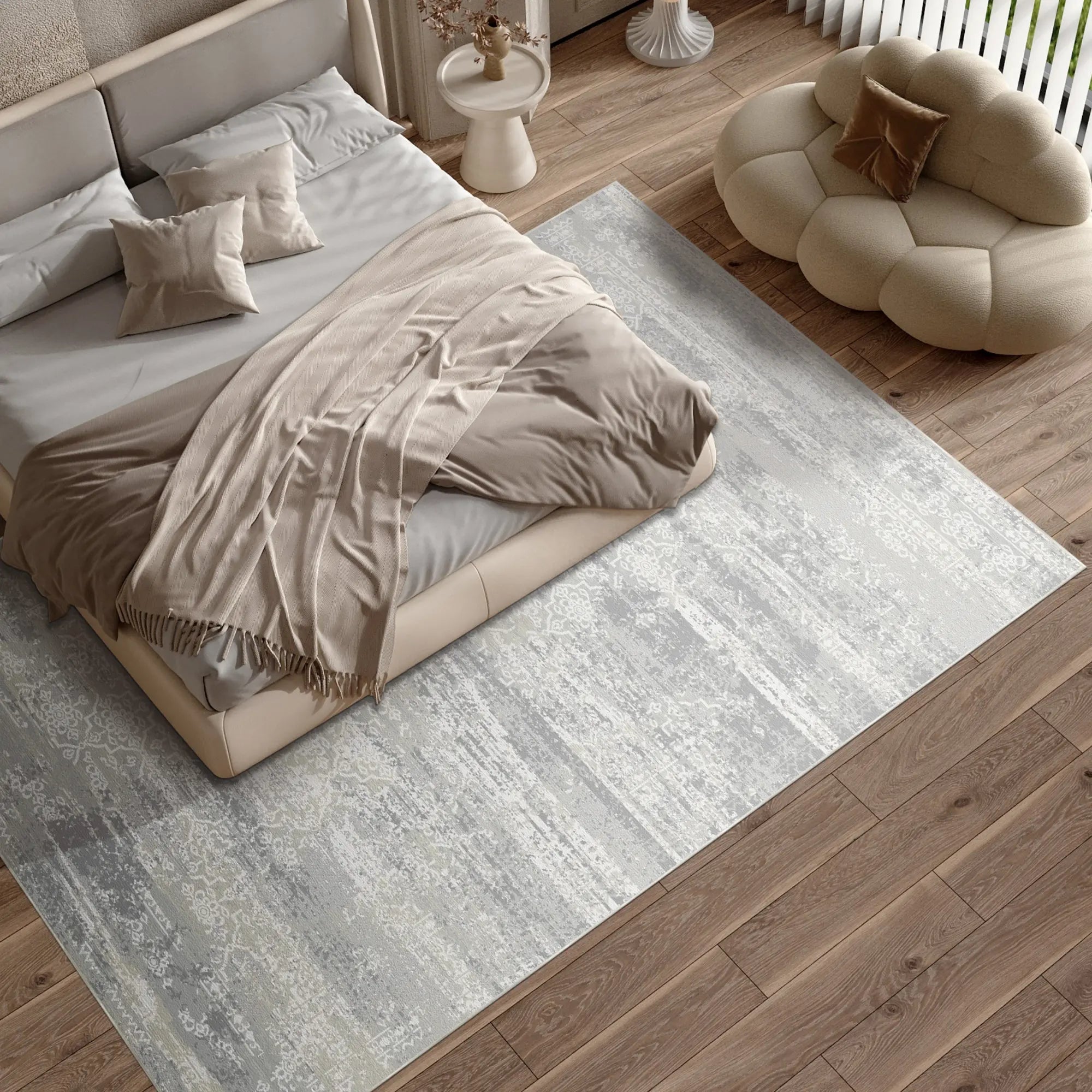 Modernes Schlafzimmer mit einem Bett, Teppich und Sessel auf einem Holzboden.